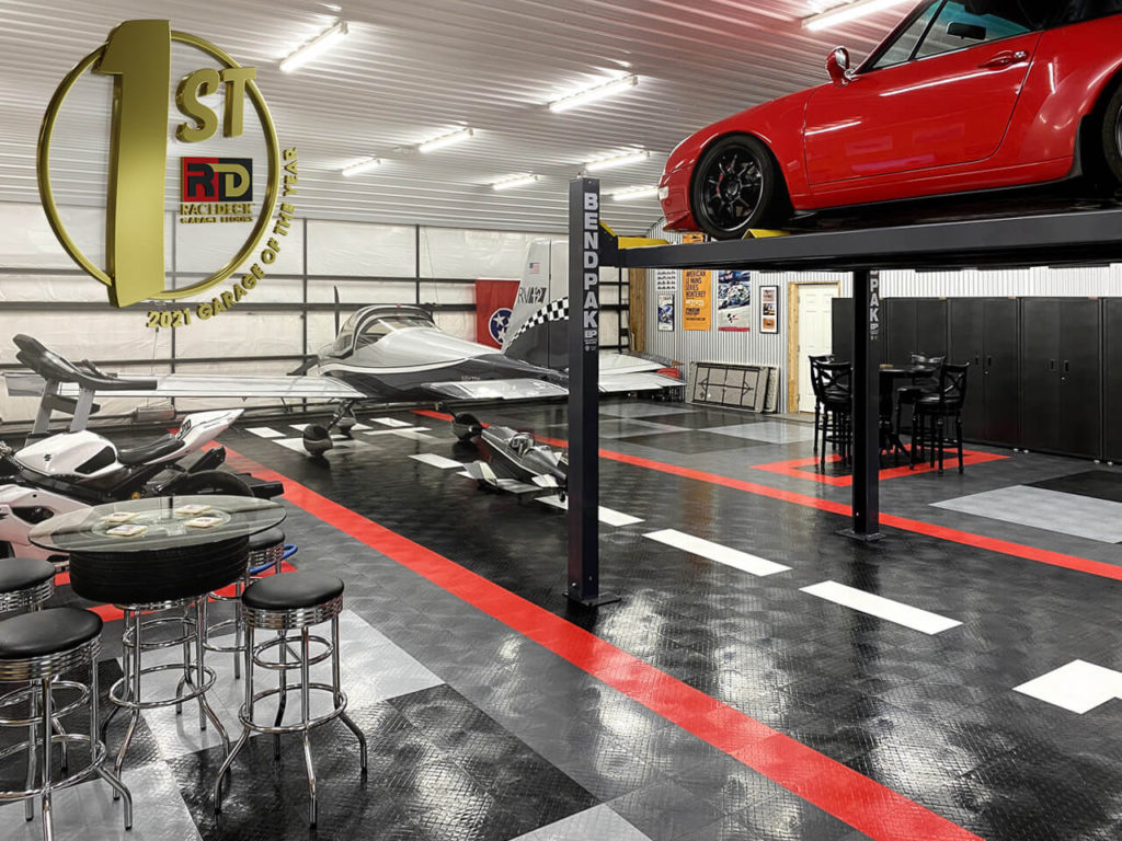Paul Straub&#039;s garage and airplane hangar with multiple rides, a lift, and floored with RaceDeck Diamond.