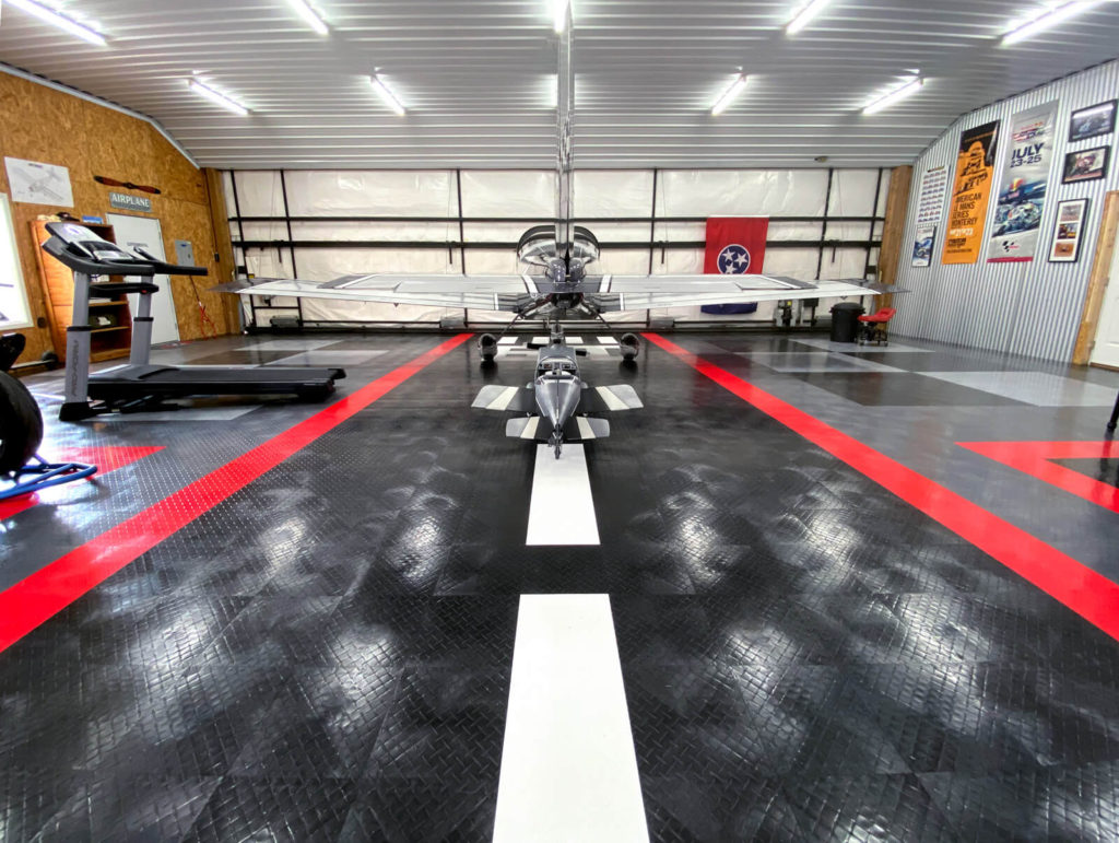 View of Paul&#039;s RaceDeck Diamond garage with airplane and exercise machines.