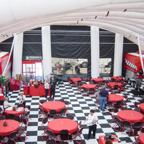 Kelley under wht tent with red tables